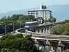 A train of the Osaka Monorail descends a grade near Senri-Chuo Station in 2011