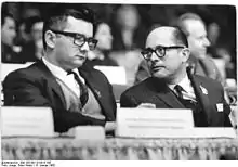 Black and white photograph of Gilberto Vieira on the right and Dr. Armando Hart on the left at the 6th congress of the Socialist Unity Party of Germany in 1963.