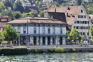 Two-story building with hip roof next to lake