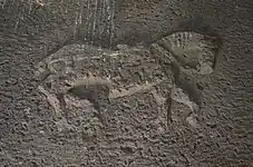 Large low-relief depiction on the interior side of the stone lintel above the entry.