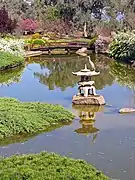 Big bird rests on a stone lantern in the upper lake