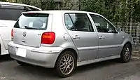 Rear-three-quarter view of a two-box car with door mirrors and a small aerodynamic spoiler atop the rear hatch