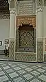 Ornate wall fountain in the main courtyard, with painted wood and zellij decoration