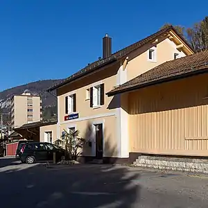 Two-story building with gabled roof and adjoining freight house