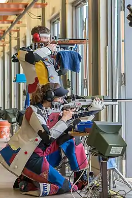 Two shooters during an ISSF 300 meter rifle three positions (prone, kneeling and standing).