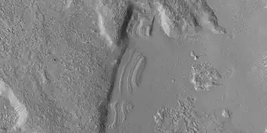 Close view of dipping layers along a mesa wall, as seen by HiRISE under HiWish program  Location is Ismenius Lacus quadrangle.