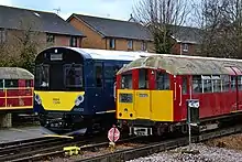 Class 484 stands next to Class 483, illustrating the difference in loading gauge between the ex-deep-level Tube Class 483 unit and the ex-sub-surface Class 484 unit.