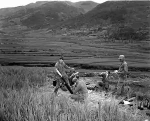 Men stand around a mortar high on a mountain