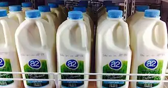 a photo of 2L bottles of A2 milk inside a supermarket fridge.