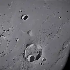 Lunar crater Krieger and vicinity, showing wrinkle ridges in the surrounding mare and sinuous rilles along the left edge, from Apollo 15