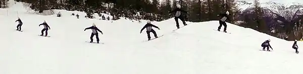 Synthetic photograph with several appearances of snowboarder gliding over a snow-covered valley