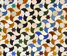 Wall tiling in the Alhambra, Spain (and the whole wall); ignoring all colors this is p3 (ignoring only star colors it is p1)