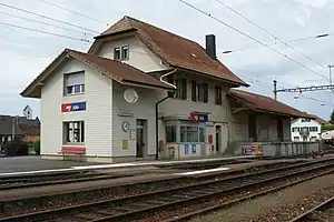 Two-story building with gabled roof and single-story wings