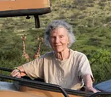 Photo of Dagg standing in a roofless vehicle with her head and shoulders facing the camera