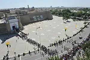 Plaze with people in front of the Ark, and walls and entrance beyond