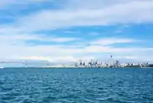 Auckland City skyline from the Waitematā Harbour, including the Harbour Bridge and Sky Tower.