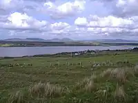 Fields and a bay, with mountains in the distance