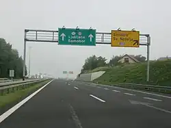 Directional traffic signs placed on a gantry ahead of a motorway exit