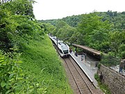 The station seen from the path to the castle, with a Stadler GTW unit on line S33 in the platform