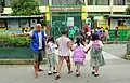 A tanod helping students cross the road at an elementary school in Santa Lucia, Dasmariñas, Cavite