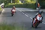 TT riders on the slight descent from the top of Barregarrow approaching the crossroads