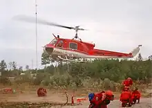 Ontario Ministry of Natural Resources firefighters prepare to deploy on an arriving contract Bell 204B on Fire 141 in 1995