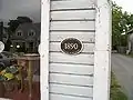 A plaque on the Historic Bellport Museum and Exchange Shop on Bell Street shows the old name of the historic district.