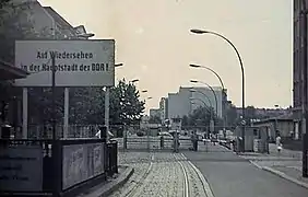 A sign reading "Until we see each other again in the capital of the GDR"