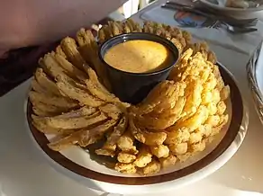 A blooming onion with dipping sauce