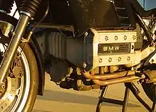 Closeup picture of BMW K100 engine. Also shows some black bodywork, forks and a front brake caliper