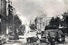 Photograph of a destroyed tank in a street