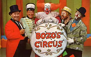 1968 postcard, main cast of Bozo's Circus (WGN-TV); left to right, Ringmaster Ned (Ned Locke), Mr. Bob (bandleader Bob Trendler), Bozo the Clown (Bob Bell), Oliver O. Oliver (Ray Rayner), Sandy the Clown (Don Sandburg)