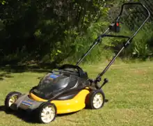 Cordless and rechargeable rotary lawn mower, in mulch mode, removable battery located above rear wheels