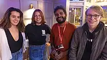 four smiling young people in casual clothing