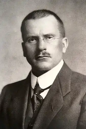 A black and white image of Carl Jung, wearing formal clothing.