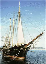 A sailing ship at a pier, starboard bow quarter view