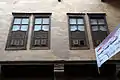 Street-facing windows of the upper floor, occupied by living apartments.