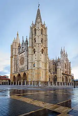 A large stone church with two large and several smaller towers and a huge rose window on the façade