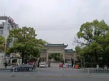 The entrance of Changsha Social Work College in Changsha, Hunan, China. The traditionally ornate styled gate is framed by leafy trees either side