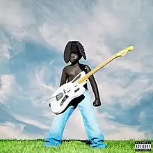 A Black child stood in a grassy field with a white guitar hanging in front of him.