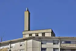 A vertical chimney erected on the mechanical penthouse of a residential high rise in Ontario for ejecting combustion products from the building's water boiler