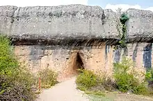 A triangular opening under a dolomitic rock.