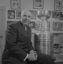 Campbell sitting on his desk with the Stanley Cup