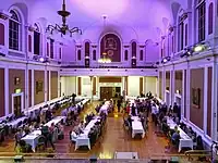 A dinner in the Large Hall of the Cambridge Guildhall viewed from its stage