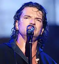 Ricardo Arjona, singing into a microphone