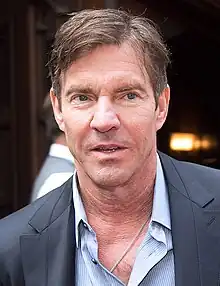 A shot of Dennis Quaid from his chest up, wearing a dress shirt and jacket.