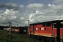 44208 crossing a 44 & 45 class hauled southbound goods train on the North Coast line in 1987