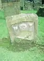 An old tombstone with skull, cross-bones and a timer