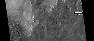 Scalloped ground, as seen by HiRISE under HiWish program. A study published in Icarus, found that the landforms of scalloped topography can be made by the subsurface loss of water ice by sublimation under current Martian climate conditions. Their model predicts similar shapes when the ground has large amounts of pure ice, up to many tens of meters in depth.