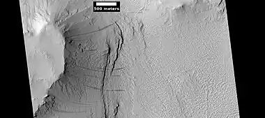 Layers under cap rock of a pedestal crater, as seen by HiRISE under HiWish program.  Pedestal crater is within the much larger Tikhonravov Crater.  Location is Arabia quadrangle.